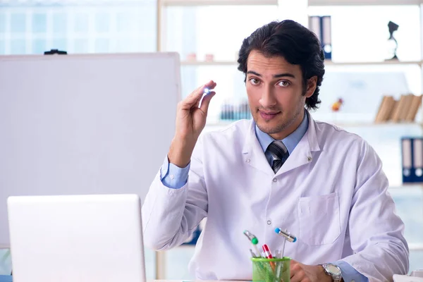 Young handsome doctor in front of whiteboard — Stock Photo, Image