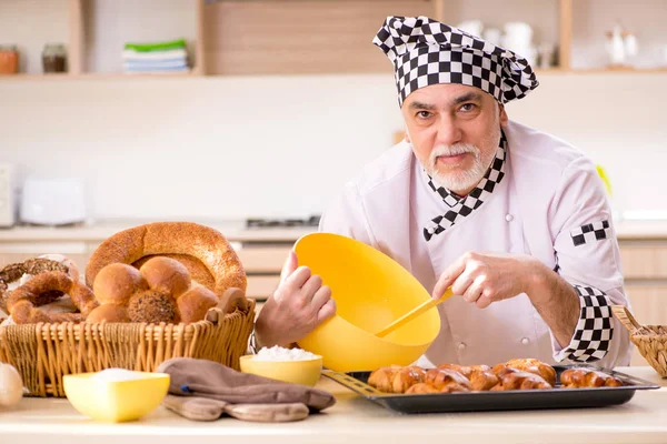 Viejo panadero trabajando en la cocina — Foto de Stock