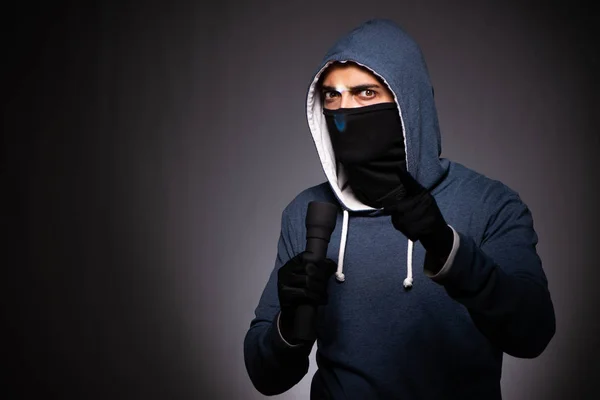 Jeune gangster à capuche sur fond gris — Photo