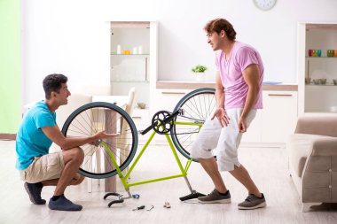 Kırık bisikletini tamir eden adam.