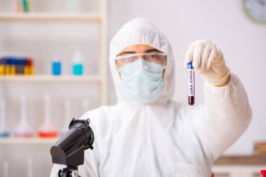 Genç yakışıklı laboratuvar asistanı hastanede kan örnekleri test ediyor. 