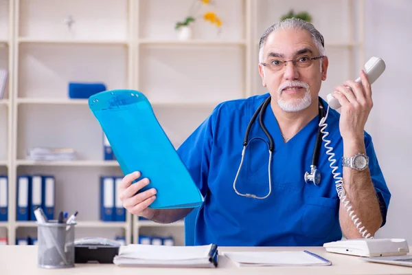 Weißbärtiger alter Arzt arbeitet in Klinik — Stockfoto