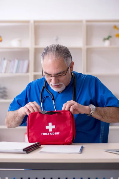 Weißbärtiger alter Arzt arbeitet in Klinik — Stockfoto