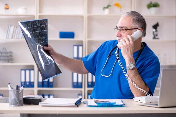 Beyaz sakallı yaşlı doktor radyolog klinikte çalışan — Stok fotoğraf