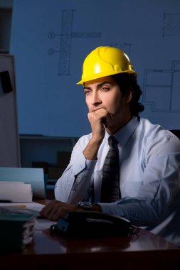 Genç inşaat mimar proje üzerinde çalışma gece 