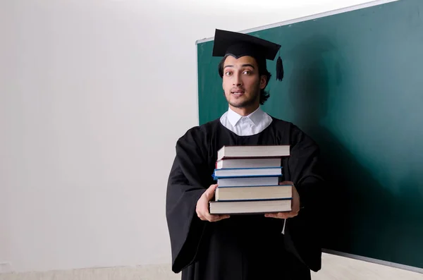 Estudante graduado na frente do quadro verde — Fotografia de Stock