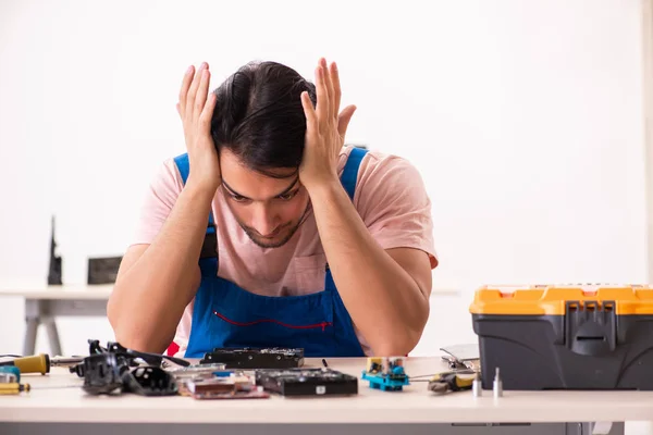 Genç bir erkek müteahhit bilgisayar tamir ediyor. — Stok fotoğraf