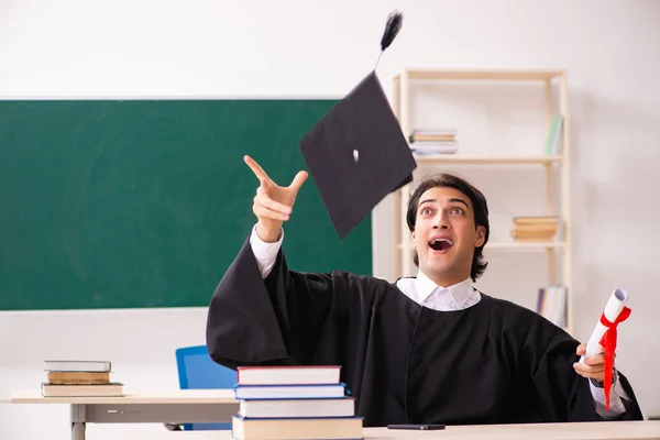 Estudante graduado na frente do quadro verde — Fotografia de Stock