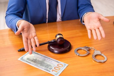 Genç yakışıklı yargıç mahkeme salonunda oturuyor  