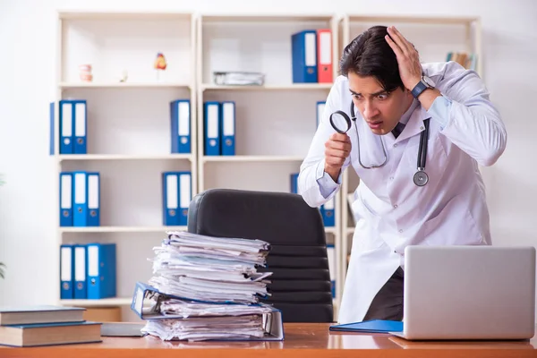 Joven médico guapo que trabaja en la clínica — Foto de Stock