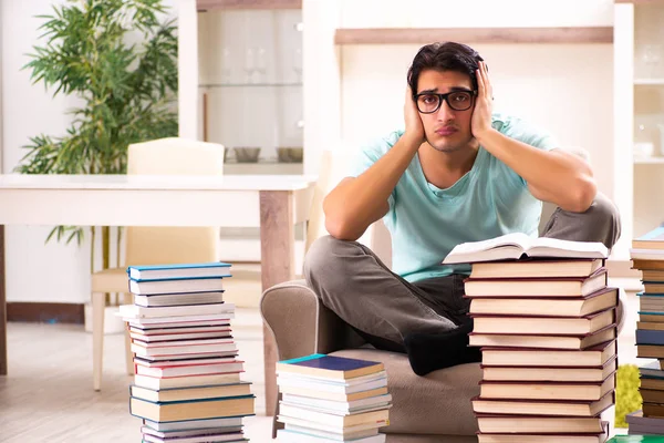 Studente maschio con molti libri a casa — Foto Stock