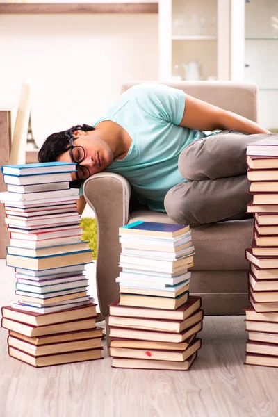 Estudiante masculino con muchos libros en casa — Foto de Stock