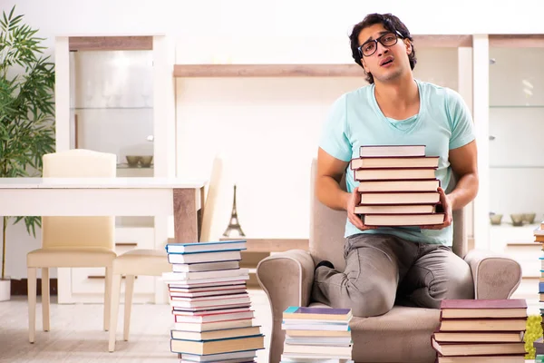 Estudiante masculino con muchos libros en casa — Foto de Stock