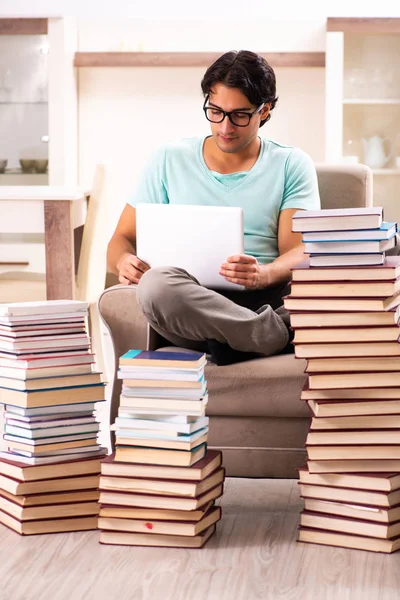 Estudante do sexo masculino com muitos livros em casa — Fotografia de Stock