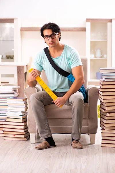 Estudiante masculino con muchos libros en casa — Foto de Stock