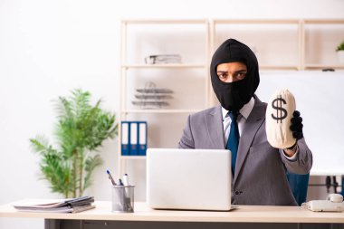 Erkek gangster ofisten bilgi çalıyor. 