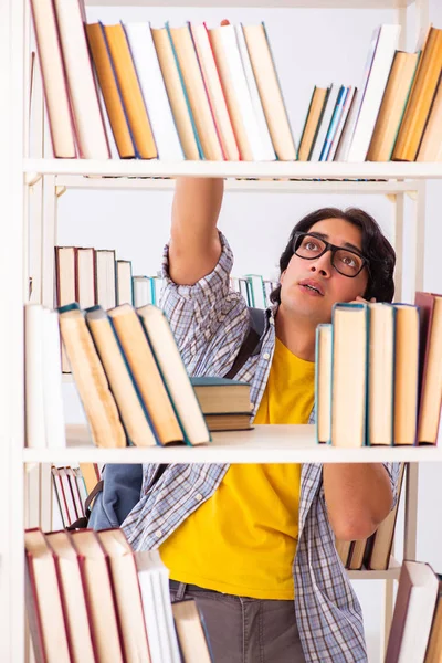Studente maschio che si prepara per gli esami in biblioteca — Foto Stock