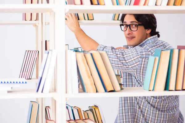 Estudante do sexo masculino se preparando para exames na biblioteca — Fotografia de Stock