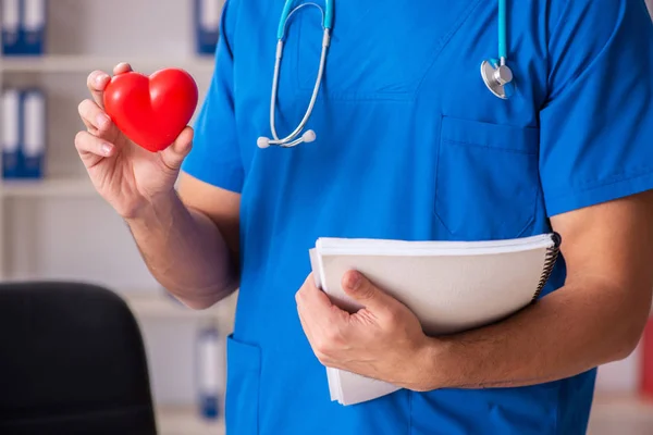 Male doctor cardiologist holding heart model — Stock Photo, Image