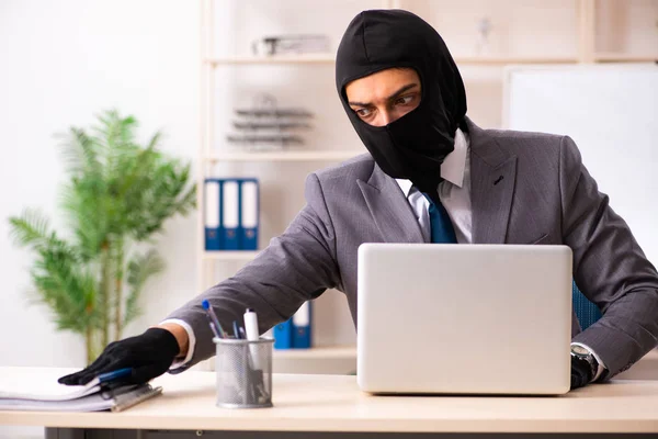 Мужчина-гангстер крадет информацию из офиса — стоковое фото