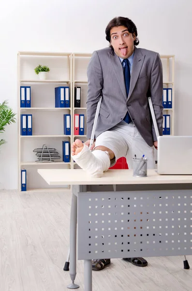 Leg injured employee working in the office — Stock Photo, Image