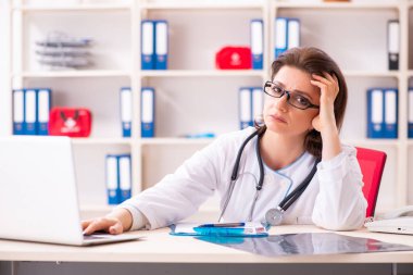 Klinikte çalışan yaşlı bir kadın doktor. 