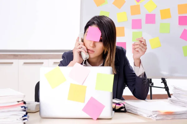 Joven empleada en el concepto de prioridades conflictivas — Foto de Stock