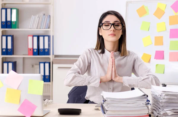 Jovem funcionária fazendo exercícios no local de trabalho — Fotografia de Stock