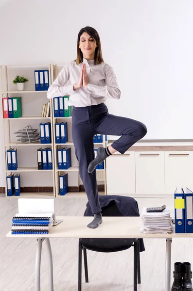 Νέος γυναίκα υπάλληλος κάνει ασκήσεις στο χώρο εργασίας — Φωτογραφία Αρχείου