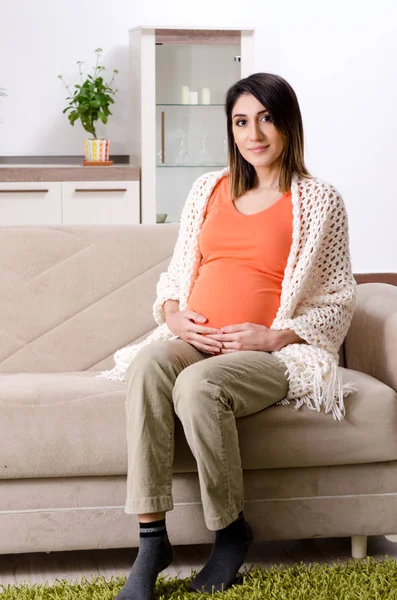 Молодая беременная женщина дома — стоковое фото