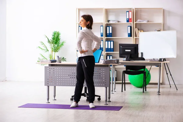 Funcionário feminino de meia-idade fazendo exercícios no escritório — Fotografia de Stock