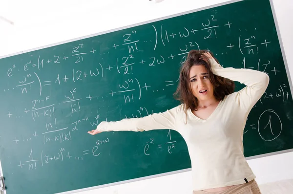 Junge Mathelehrerin vor der Tafel — Stockfoto