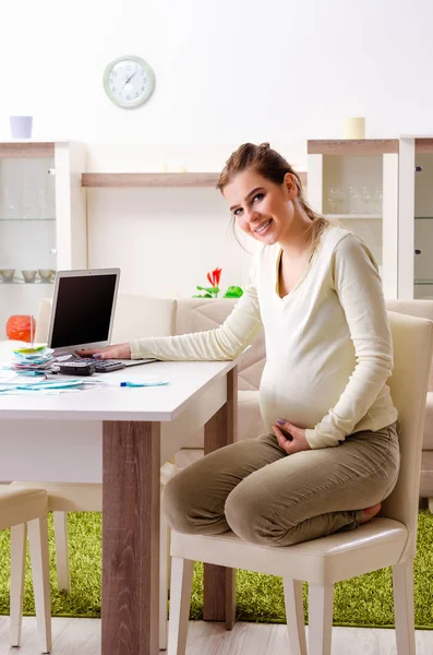 Jonge zwangere vrouw in budget planning concept — Stockfoto