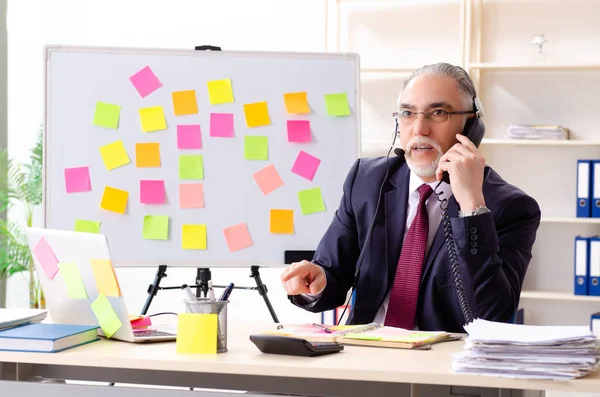 Leeftijd man werknemer in tegenstrijdige prioriteiten concept — Stockfoto