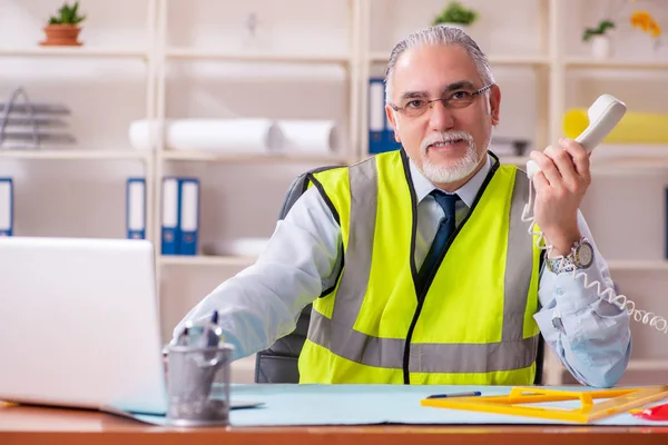 Betagter Bauingenieur arbeitet im Büro — Stockfoto