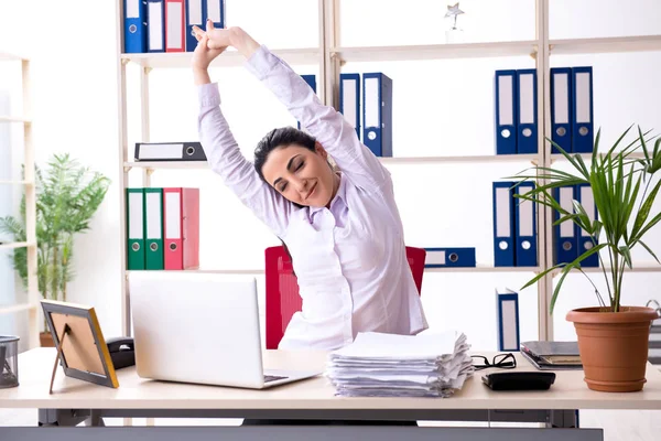 Jovem funcionária fazendo exercícios no escritório — Fotografia de Stock