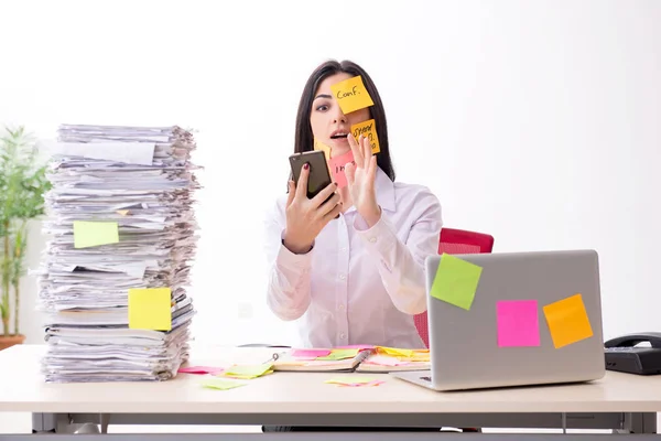 Joven empleada en el concepto de prioridades conflictivas — Foto de Stock