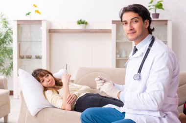Genç, yakışıklı doktor, kadın hastayı evinde ziyaret ediyor. 