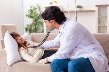 Genç, yakışıklı doktor, kadın hastayı evinde ziyaret ediyor. 