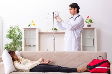 Genç, yakışıklı doktor, kadın hastayı evinde ziyaret ediyor. 