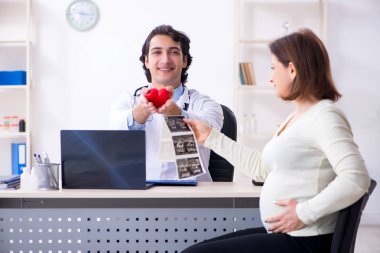 Yaşlı hamile kadın ziyaret genç erkek doktor 