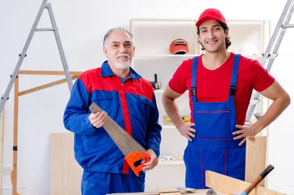 Two professional contractors laying flooring at home