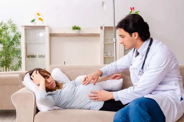 Ung stilig läkare besöker gravid kvinna hemma — Stockfoto