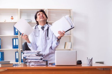 Klinikte çalışan yakışıklı genç bir doktor. 