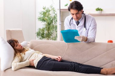 Genç, yakışıklı doktor, kadın hastayı evinde ziyaret ediyor. 