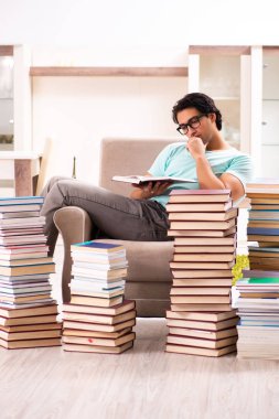 Evde pek çok kitap ile erkek öğrenci 