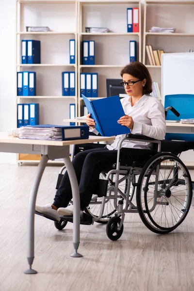 Employée en fauteuil roulant au bureau — Photo