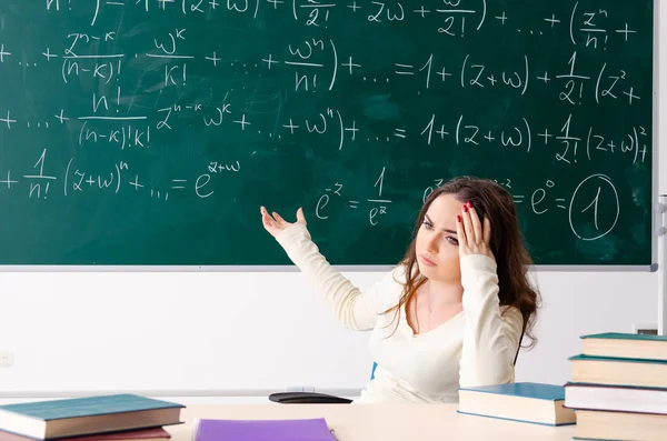 Mladá žena učitel matematiky před tabulí — Stock fotografie