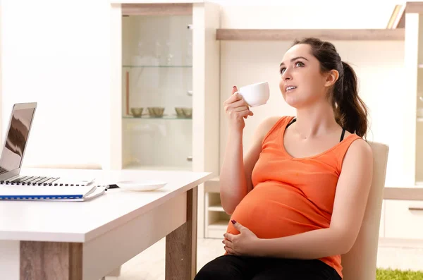 Giovane donna incinta che lavora a casa — Foto Stock