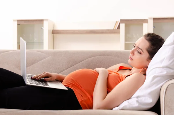 Giovane donna incinta che lavora a casa — Foto Stock